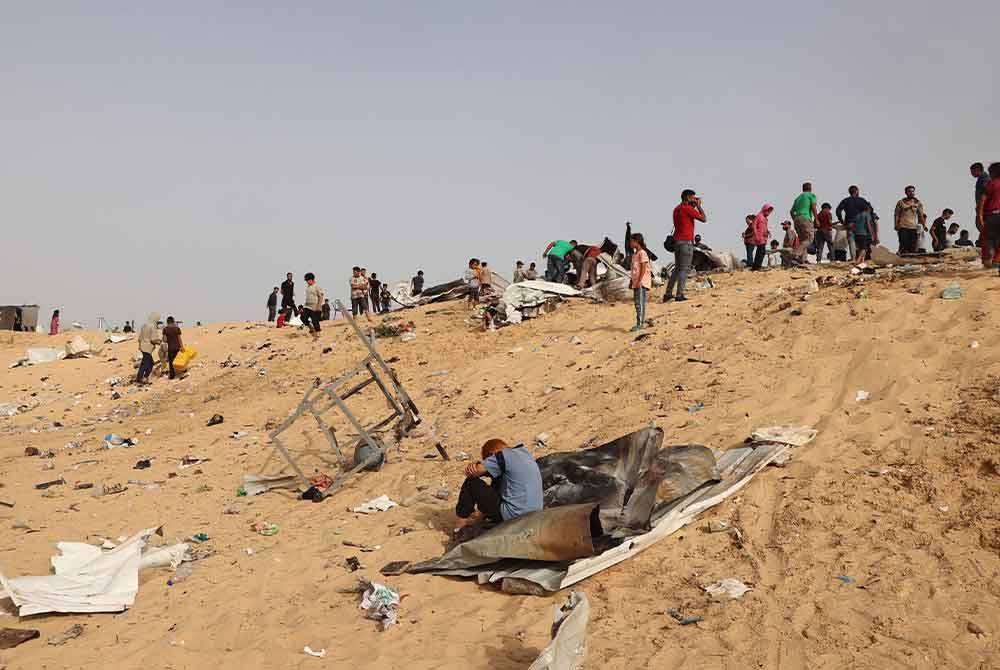Penduduk Palestin berkumpul di tapak serangan Israel di kem pelarian di Rafah. Foto AFP