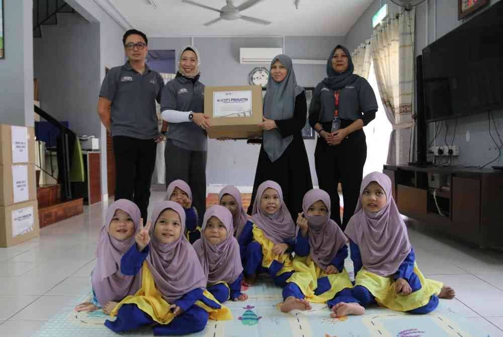 Dr Faizah (dua dari kiri) menyerahkan sumbangan kepada wakil Rumah Amal Al-Firdaus di Denai Alam.