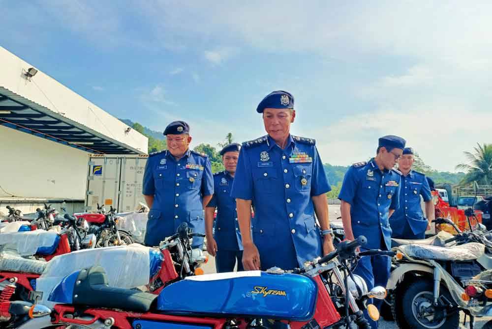 Abdul Ghafar (depan) menunjukkan motosikal pelbagai model berjenama Sky Team bernilai lebih RM1 juta disyaki barang belum lulus kastam.