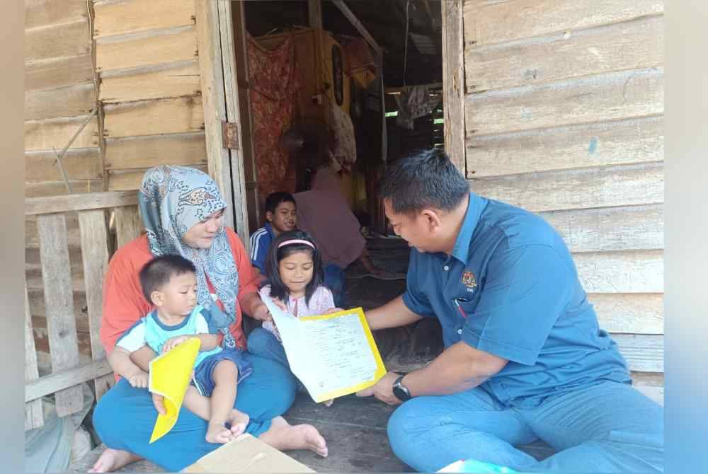 Badrul Hisham (kanan) menyerahkan sijil kelahiran kepada Siti Zulaikha (kiri)