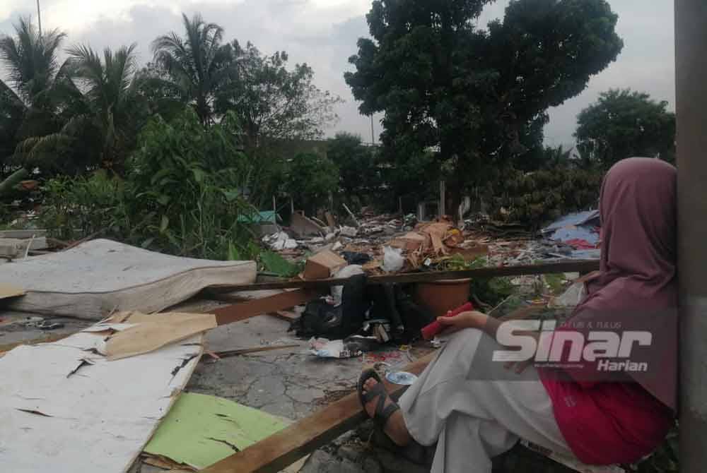Seorang penduduk dilihat termenung melihat rumah yang telah dirobohkan menerusi operasi dijalankan pada Isnin lalu.
