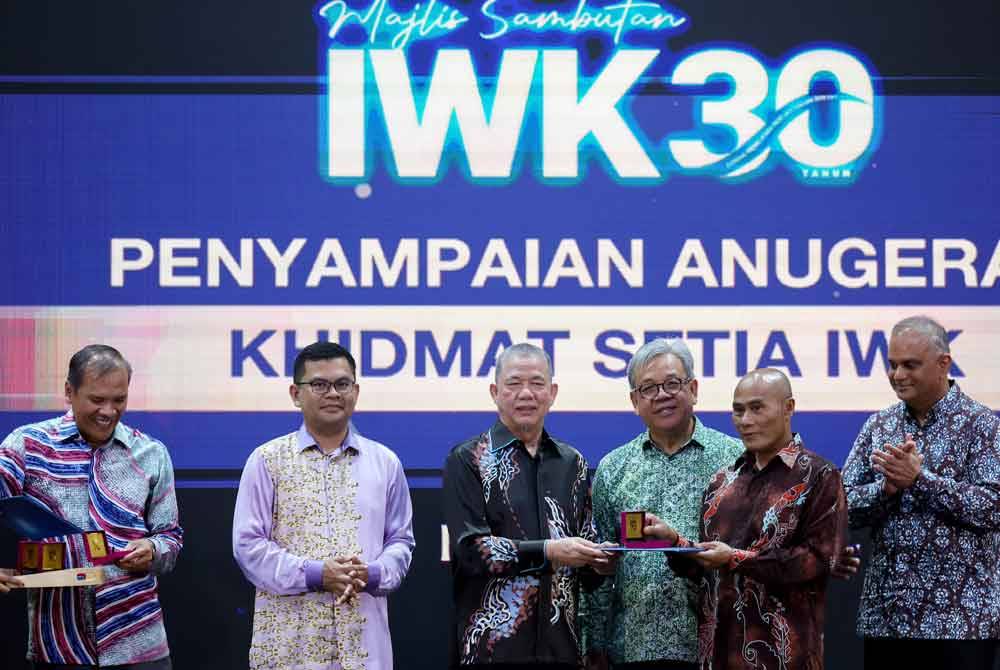 Timbalan Perdana Menteri yang juga Menteri Peralihan Tenaga dan Transformasi Air Datuk Seri Fadillah Yusof (tiga, kiri) menyampaikan anugerah kepada kakitangan IWK yang telah berkhidmat selama 30 tahun pada Majlis Sambutan 30 Tahun Indah Water Konsortium (IWK) di IWK Eco Park pada Khamis. Foto Bernama