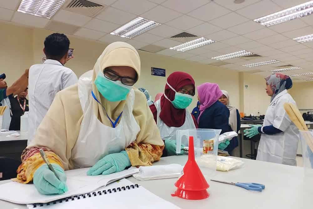 Salah seorang peserta membuat catatan bahan yang diguna pakai dalam pembuatan sabun ketika mengikuti bengkel pembuatan sabun di UiTM Cawangan Perak Kampus Tapah.