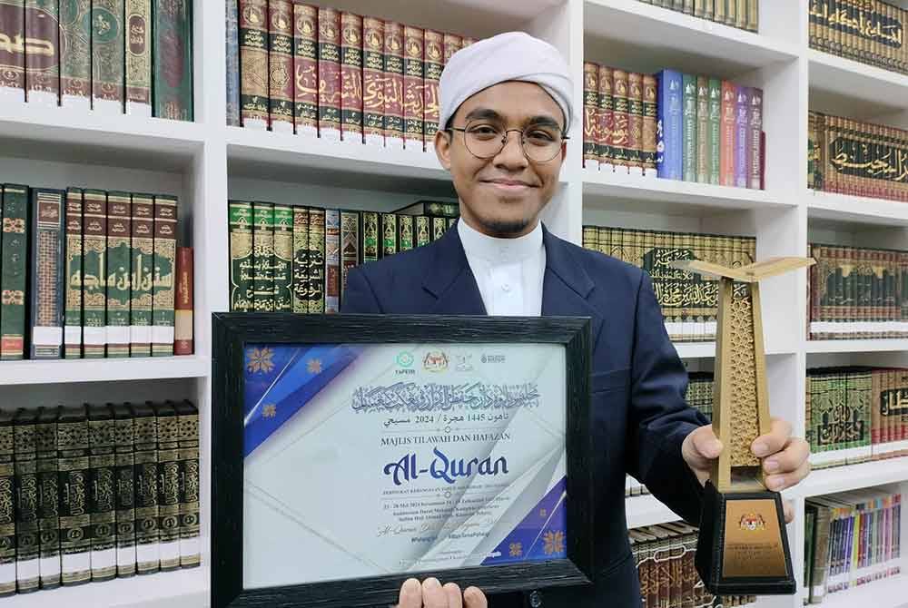 Muhammad Rifae'i menunjukkan sijil dan trofi setelah diumumkan johan hafazan Majlis Tilawah dan Hafazan Al-Quran Peringkat Kebangsaan.