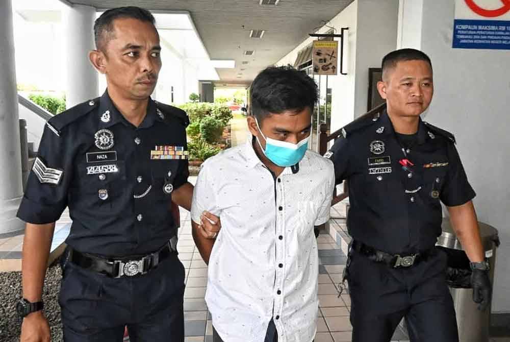 Muhammad Akmal (tengah) ketika dibawa keluar dari Mahkamah Majistret di sini, pada Jumaat selepas didakwa atas dua pertuduhan.