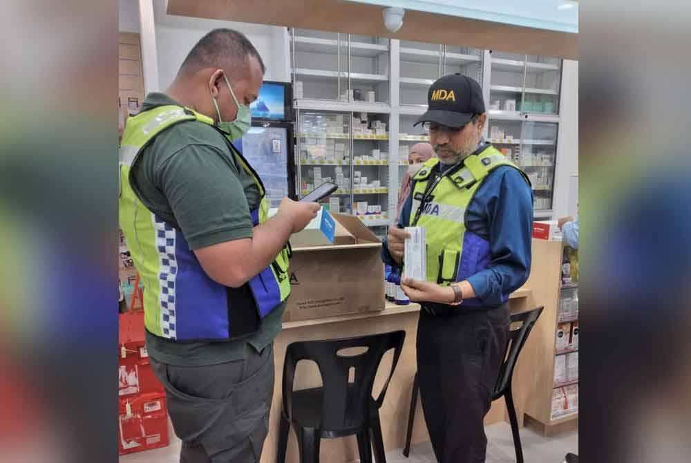 Muralitharan (kanan) sedang melakukan pemeriksaan terhadap peranti perubatan yang dijual di farmasi.