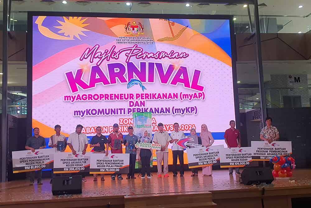 Adnan (enam dari kanan) bergambar dengan penerima bantuan yang disediakan oleh Jabatan Perikanan.