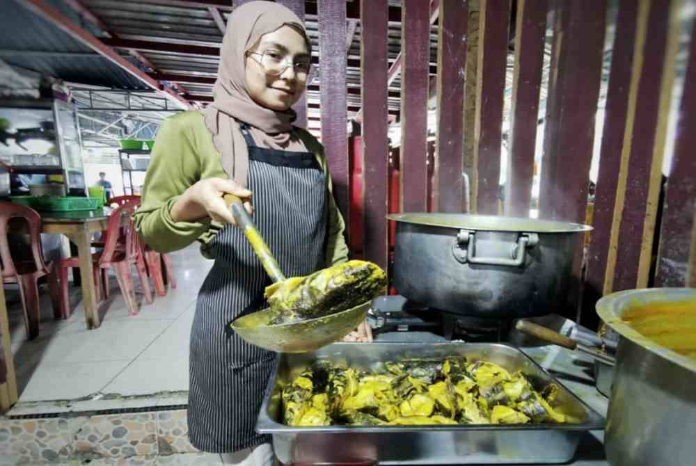 Fatin Azuin tidak menang tangan menyediakan ikan baung masak tempoyak yang menjadi kegemaran pelanggan apabila berkunjung ke restoran itu.