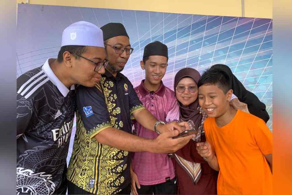 Ammar Zafran (tiga dari kiri) melihat keputusannya bersama bapanya, Ziyauddin (dua dari kiri) dan ibunya, Asmaniza (empat dari kiri) serta ahli keluarga lain ketika pengumuman keputusan SPM baru-baru ini.