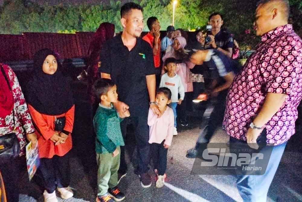 Rais (kanan) beramah mesra dengan pengunjung yang hadir memeriahkan program itu.