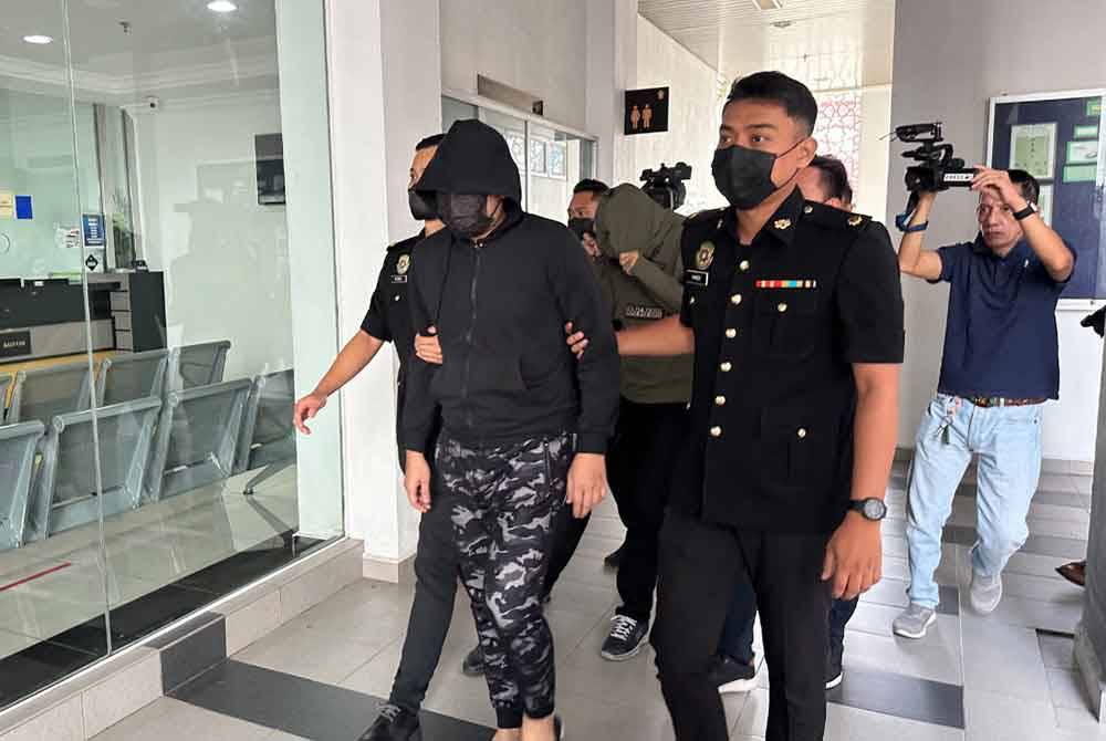 Kedua-dua tertuduh menutup muka ketika keluar dari bilik mahkamah selepas dituduh.