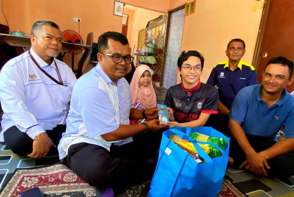 Raja Amirul Mukmin (dua dari kanan) menerima sumbangan wang tunai dan bakul makanan yang diserahkan oleh Zainuddin yang mewakili Setiausaha Politik Perdana Menteri, Ahmad Farhan Fauzi.