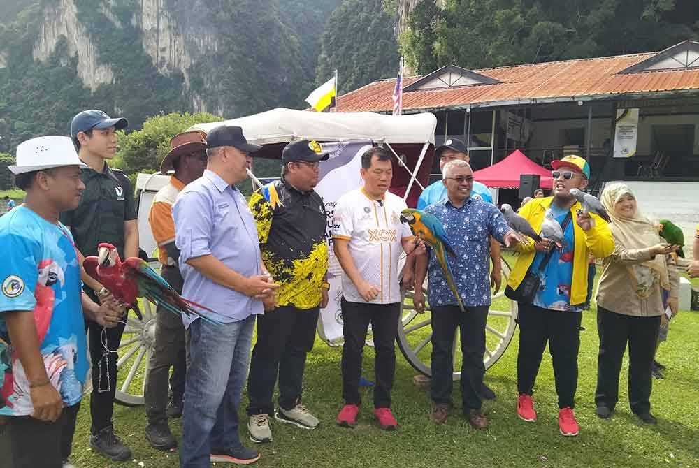 Sze Yee (empat dari kanan) bersama salah satu burung kakak tua ketika menyempurnakan Perasmian Persatuan Kakak Tua Perak di Iskandar Polo di sini pada Ahad.