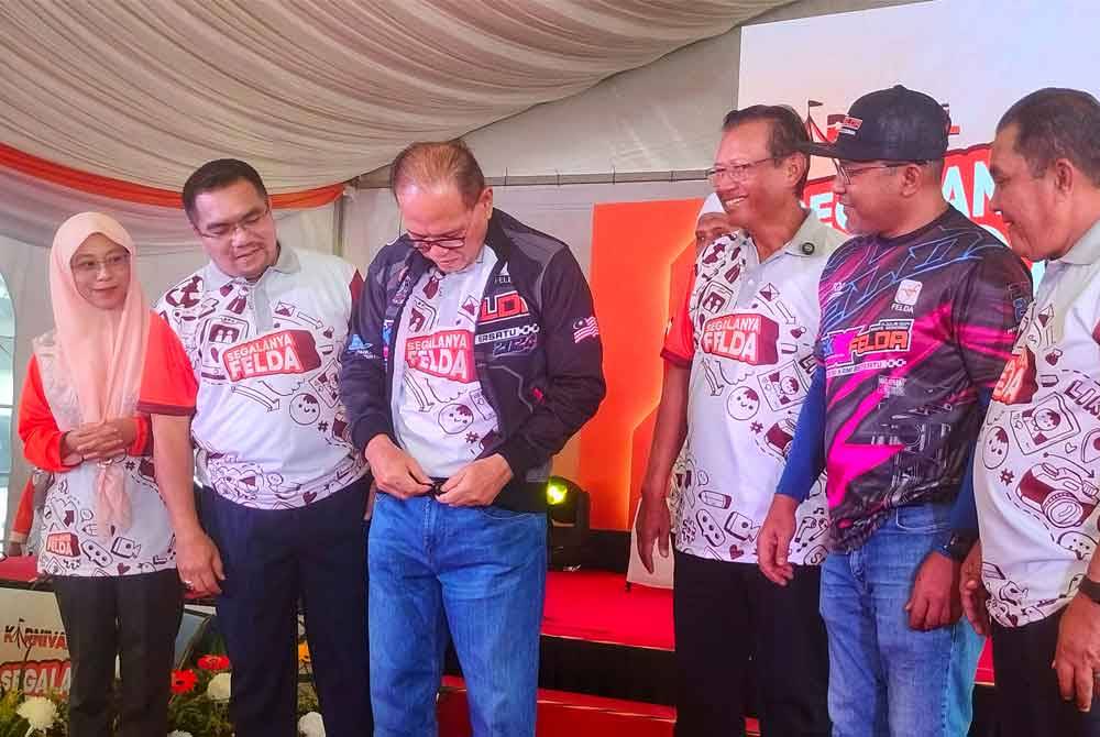 Wan Rosdy (tiga dari kiri) mencuba jaket khas Jambori dan Himpunan Dua Roda sempena Karnival Segalanya Felda peringkat Kebangsaan di Maeps, Serdang pada Julai depan.