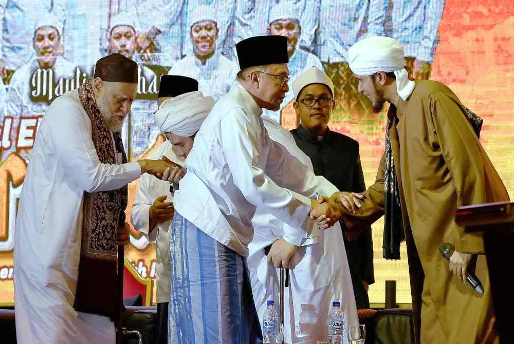 Anwar (tengah) bersama Bekas Mufti Agung Negara Mesir, Al-Imam Al-Allamah Prof De Ali Jum'ah (kiri) pada Mawlid Akbar Darul Ehsan Berselawat di Dataran Tapak Karnival Pekarangan Stadium Shah Alam pada Ahad. Foto Bernama