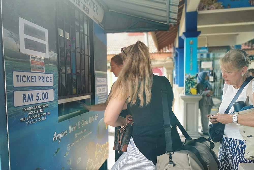 Beberapa pelancong asing yang tiba di Jeti Pelancongan Kuala Besut membayar caj perkhidmatan dan kemasukan ke Pulau Perhentian.