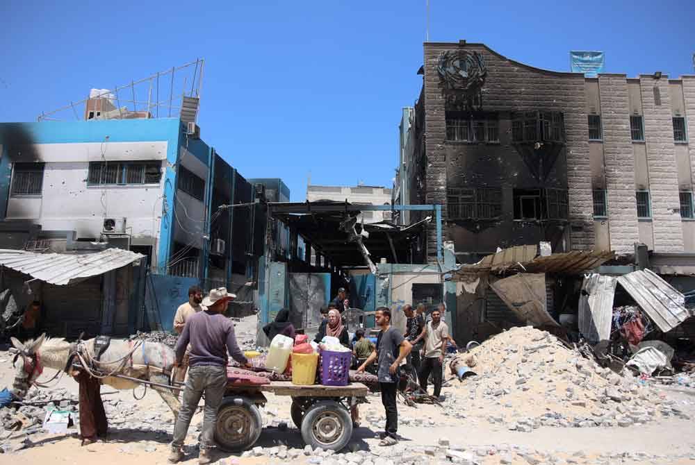 Sebuah keluarga mendapatkan barangan yang masih lagi boleh digunakan di sekolah kendalian Pertubuhan Bangsa-Bangsa Bersatu (PBB) yang turut menjadi sasaran bedilan.