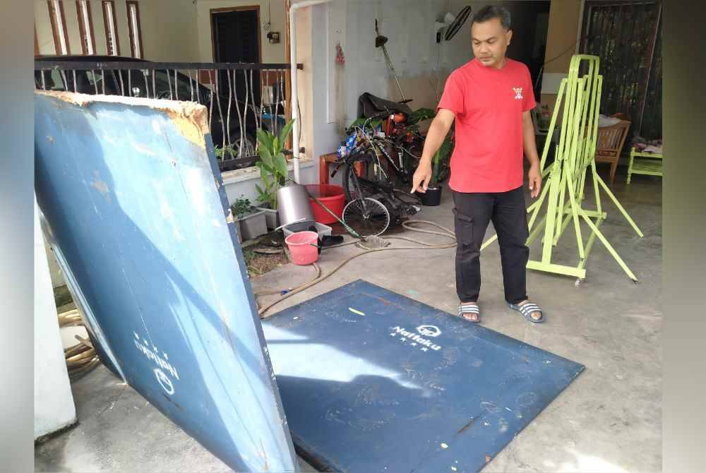 Mohd Nazri menunjukkan peralatan sukan miliknya rosak akibat banjir lumpur yang berlaku baru-baru ini.