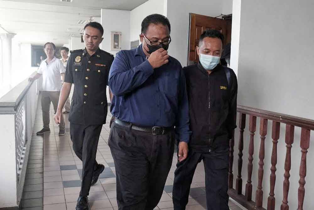 Razizam (tengah) ketika dibawa keluar dari Mahkamah Sesyen, di sini, pada Selasa.