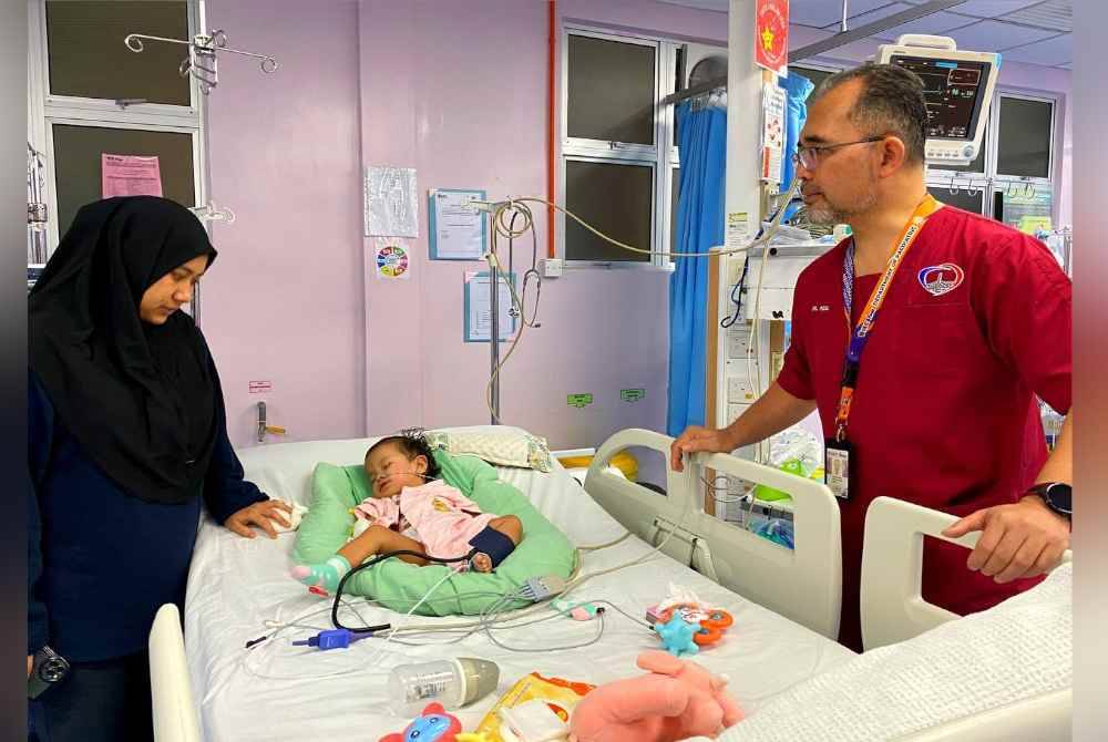 Dr Mohd Rizal (kanan) memeriksa kanak-kanak yang telah menjalani pembedahan di HUSM pada Rabu.