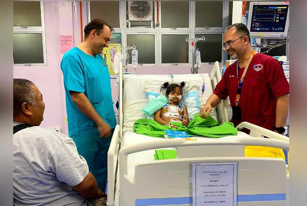 Dr Mohd Rizal (kanan) bersama Dr Haris (kiri) memeriksa salah seorang pesakit berusia tujuh tahun yang telah berjaya menjalani pembedahan jantung di HUSM pada Rabu.