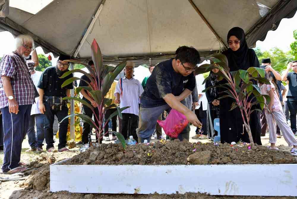 Ashman Mohd Supyan Abdul Rahman menaburkan bunga mawar di pusara bapanya penyair dan pelakon Mohd Supyan Abdul Rahman, 66, atau lebih dikenali sebagai Pyan Habib di Tanah Perkuburan Islam AU4, Lembah Keramat, pada Rabu. Foto Bernama