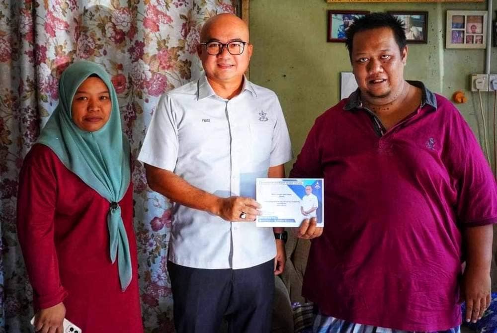 Allahyarham Mohd Zulkifli (kanan) bersama Nurul Shada ketika menerima sumbangan kerajaan negeri yang disampaikan Exco Komunikasi dan Multimedia, Belia, Sukan dan Badan Bukan Kerajaan negeri, Fadzli Mohamad Kamal pada April lalu.