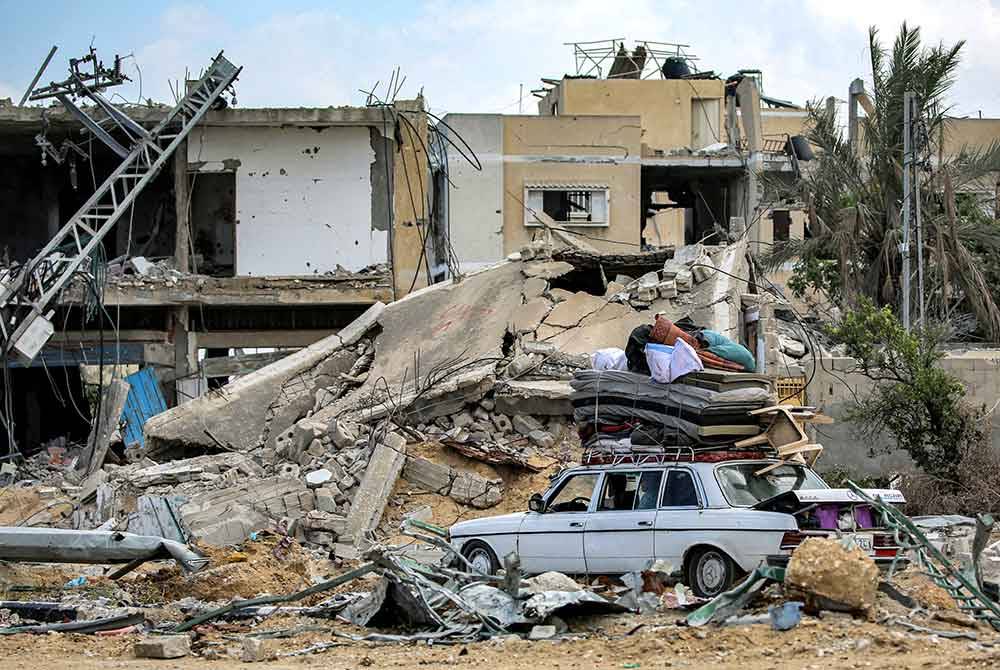 Tilam dan beberapa barangan yang masih boleh digunakan diambil dari runtuhan sebuah bangunan di Khan Yunis.