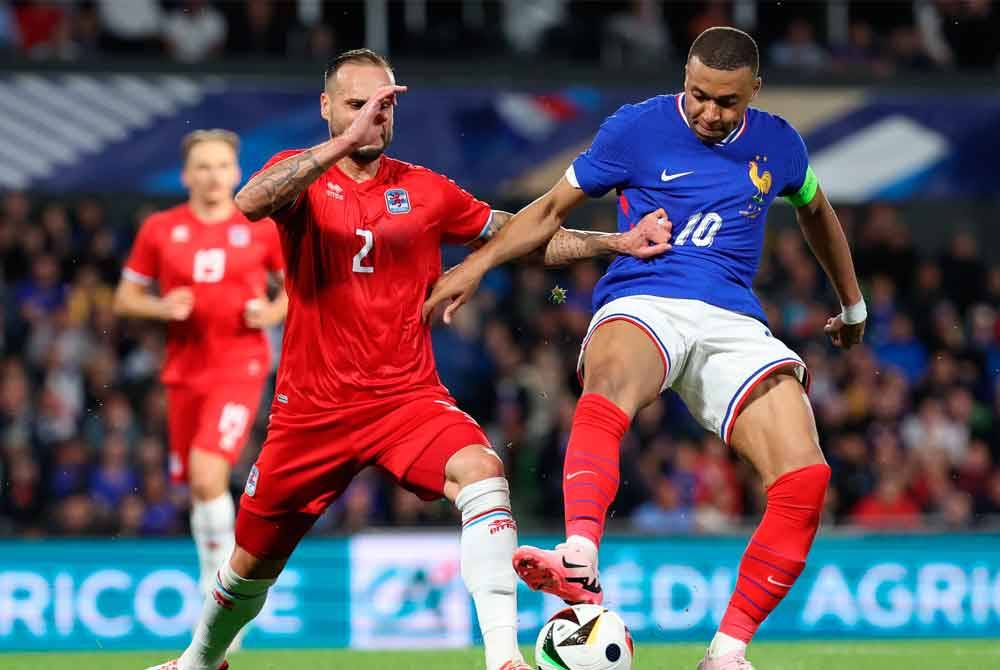 Mbappe (kanan) dicabar oleh pemain Luxembourg, Maxime Chanot ketika aksi persahabatan di Metz. Foto EPA