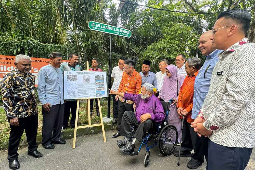 Zairil (enam dari kiri) menerangkan tentang penukaran nama jalan kepada Ahmad Jamil (berkerusi roda) pada Majlis Pertukaran Nama Jalan pada Khamis.