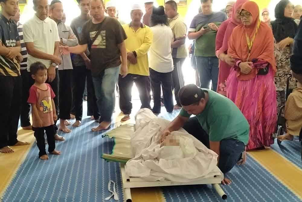 Abu Dzar menatap wajah ayahnya buat kali terakhir di Masjid Nurul Hamidiyah Tanjung Tualang sebelum disemadikan di Tanah Perkuburan Islam Tanjung Tualang di Kampar pada Khamis.