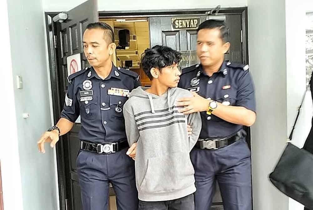 Tertuduh, Feri (tengah) ketika dibawa keluar dari Mahkamah Majistret di sini, pada Khamis.