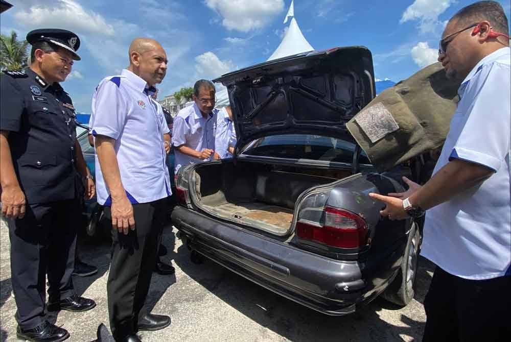 Armizan (dua, kiri) melihat kenderaan sedan yang diubah suai oleh penyeludup untuk tujuan penyeludupan bahan api ke negara jiran semasa lawatan beliau di sempadan Malaysia-Thailand di Sungai Golok, Pengkalan Kubor, Tumpat Khamis.