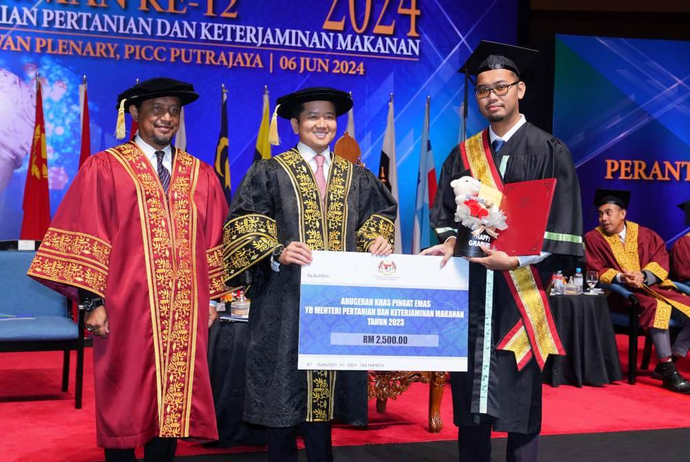 Arthur (tengah) menyampaikan Anugerah Khas Pingat Emas Menteri KPKM kepada Ahmad Noor Fariz Mohd Isa. Foto SINAR HARIAN- MOHD HALIM ABDUL WAHID