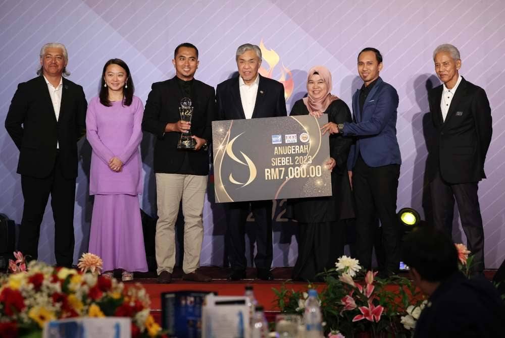 Ahmad Zahid (tiga dari kanan) menyampaikan hadiah kepada Atlet boling padang negara, Nur Ain Nabilah Tarmizi (tiga dari kiri) dan Aleena Ahmad Nawawi (dua dari kanan) yang memenangi anugerah Atlet Terbaik pada Majlis Anugerah Penulis-Penulis Sukan Malaysia (SAM) 100 Plus 2023 di sebuah hotel malam Khamis. Foto Bernama