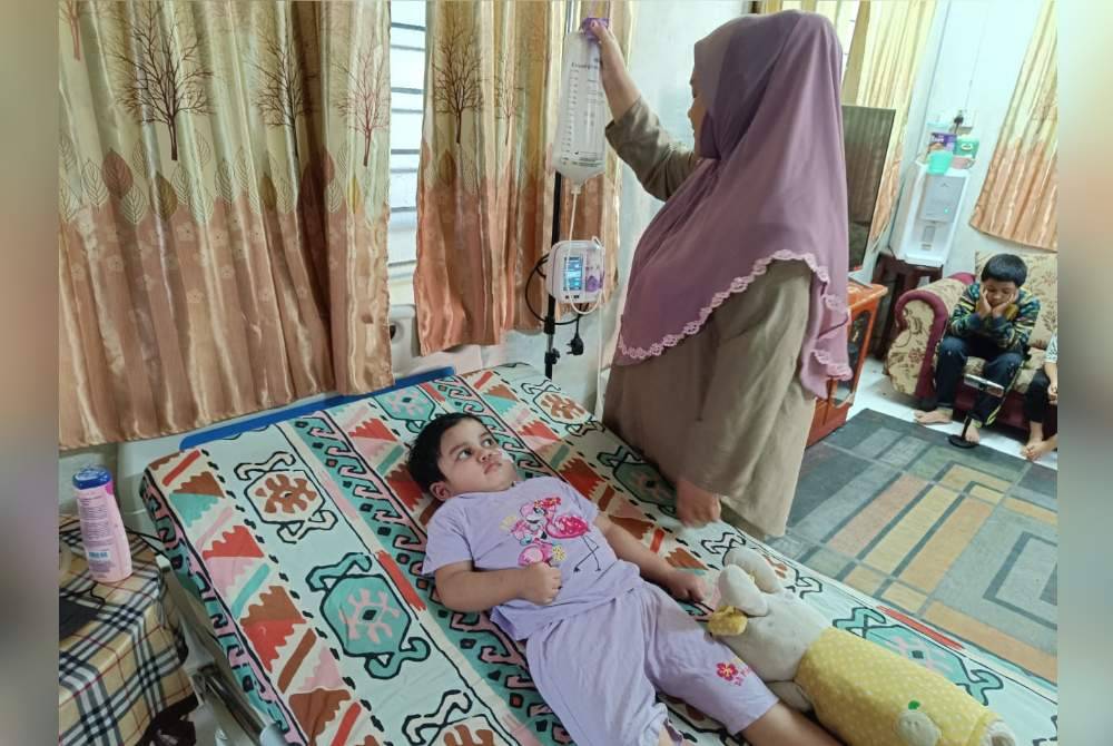 Engku Noor Wahidah memeriksa mesin untuk tiub saluran anaknya yang terlantar.