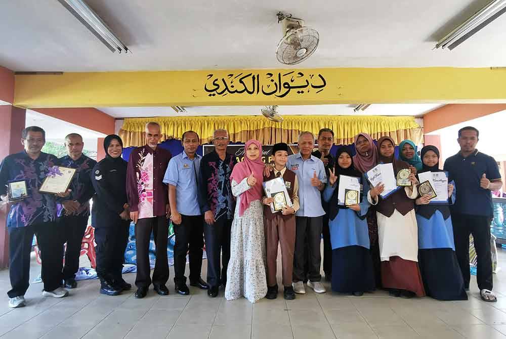 Muhammad Nasir (tengah) merakam gambar bersama murid cemerlang dalam Ujian Penilaian Kelas Kafa (UPKK) 2023/2024.