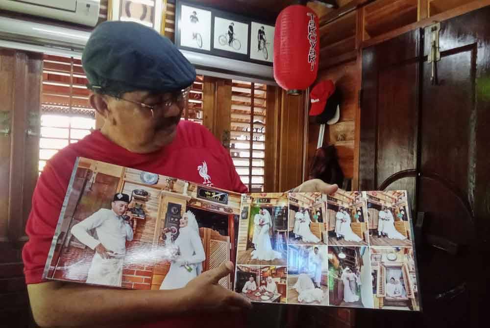 Mohd Noor menunjukkan album pengantin yang membuat fotografi di kediamannya.