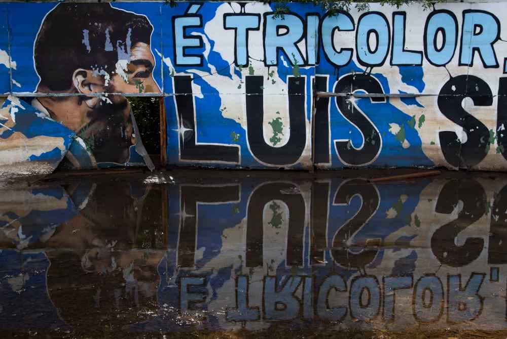 Mural dinding wajah pemain bola sepak, Luis Suarez disaksikan di jalan raya yang dinaiki air di stadium Arena do Gremio di Brazil. AFP