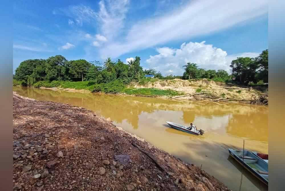 Seorang penduduk menggunakan bot fiber untuk menyeberangi sungai Kampung Aur untuk ke rumahnya di kampung Seberang Aur, Bukit Ibam pada Sabtu.