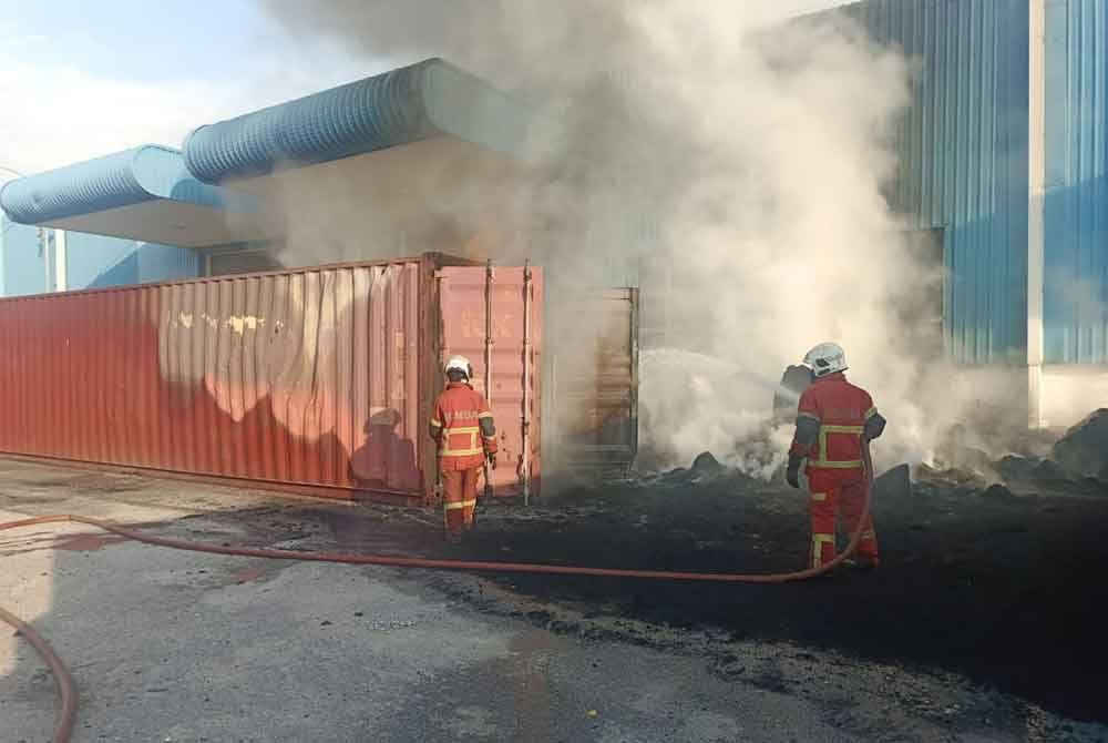 Anggota bomba memadamkan kebakaran kontena di Pelabuhan Barat dekat sini pada Sabtu.