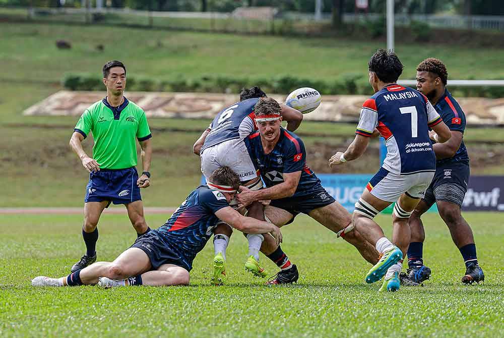 Aksi pemain ragbi Hong Kong menghalang pemain Malaysia, Syarif Nurhidayat Muzhaimey (tengah) pada Kejohanan Ragbi Asia 2024 di Stadium UPM pada Sabtu. Foto Bernama