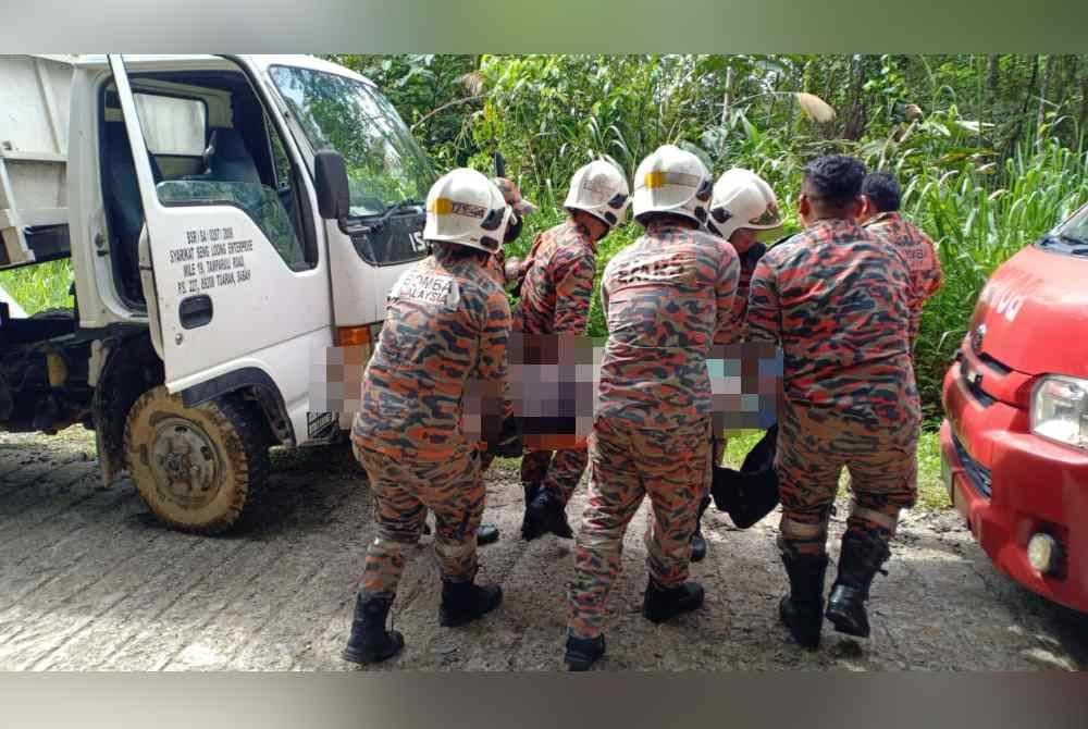 Pasukan bomba membawa mangsa keluar selepas tersepit di bahagian bawah lori.
