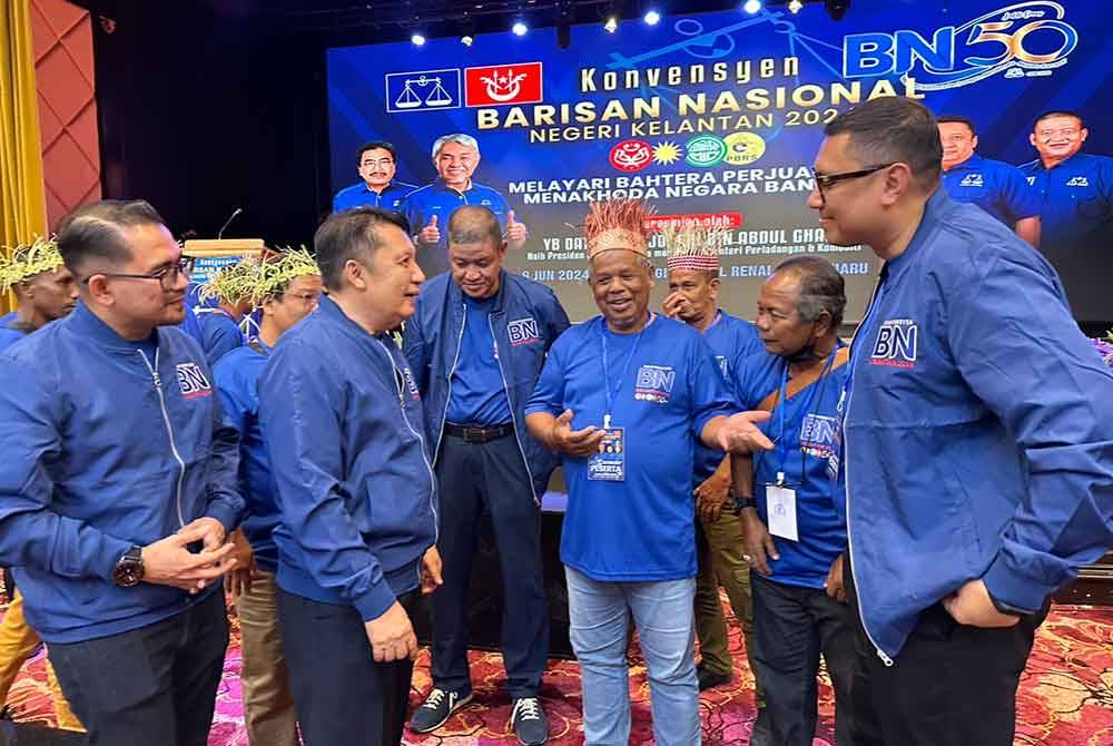 Ahmad Jazlan (dua dari kiri) beramah-mesra dengan hadirin daripada komuniti Orang Asli.