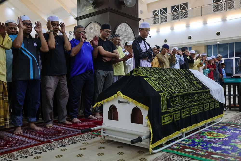 Anggota keluarga serta penduduk setempat menunaikan solat jenazah di Masjid Abdullah Fahim. Foto Bernama
