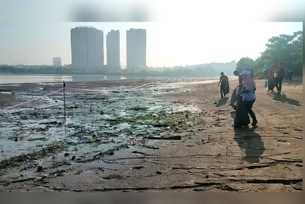 Sukarelawan mengutip sampah di Sungai Skudai pada Ahad.