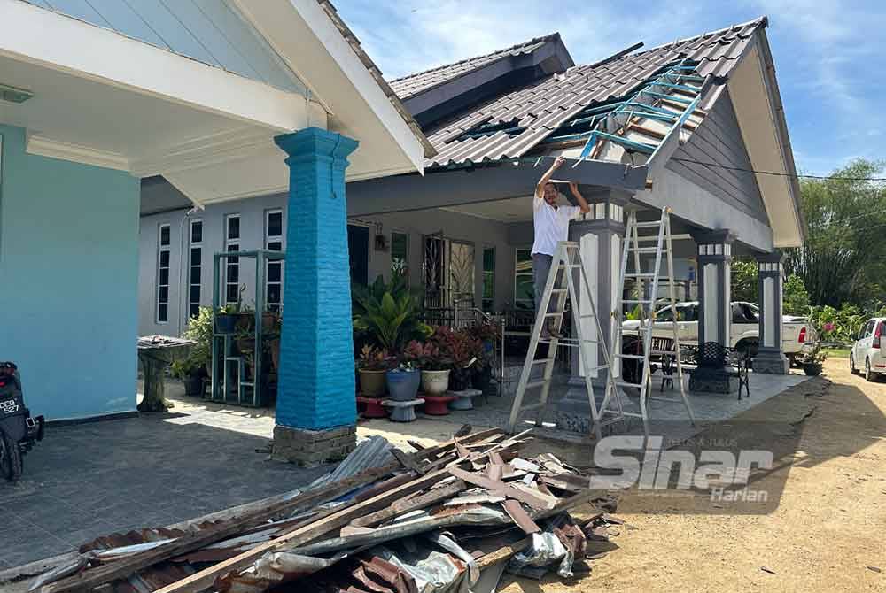 Penduduk melihat bumbung rumah yang rosak. Foto Sinar Harian