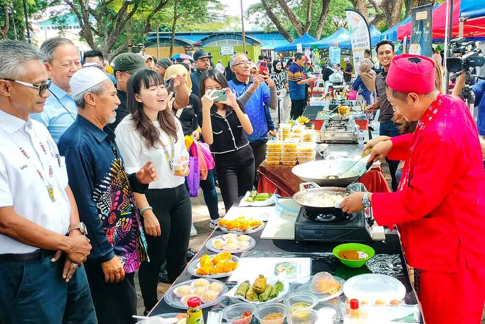 Yu Man (tiga dari kiri) tertarik melihat makanan yang disediakan peserta Indonesia sambil diperhatikan Sahariman(dua dari kiri) dan Suris(kiri).