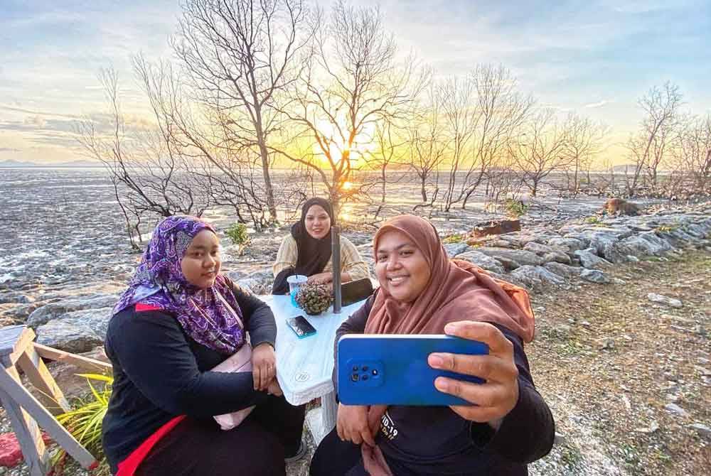 Nur Najihah berswafoto bersama rakan-rakan berlatar belakangkan panorama indah di Pulau Ketam.