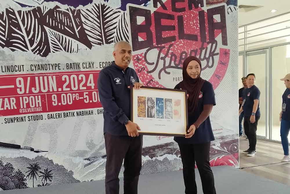 Khairudin (kiri) menerima cenderahati selepas merasmikan penutupan Program Kem Belia Kreatif 2024 di Bazar Ipoh, Silveritage pada Ahad.